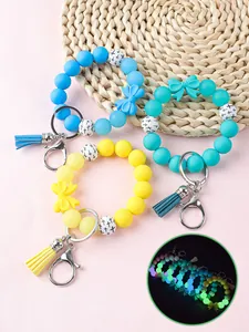 Kleurrijke siliconen kralen polsband sleutelhangers met strikken en glow-in-the-dark effect.