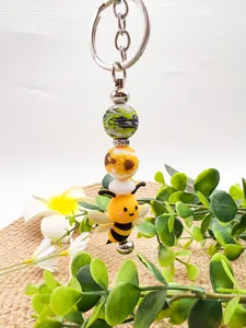 Detailed view of a cute cartoon bee silicone beaded keychain with sunflower patterns