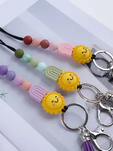 Close-up of three handmade silicone beaded keychains featuring sun and rainbow charms.