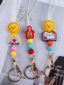 Close-up of three colorful cartoon sun and school themed silicone beaded keychains