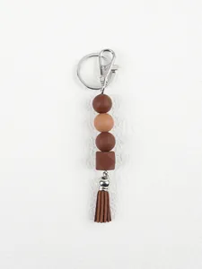 Detailed macro view of handmade earth-tone silicone bead keychain with brown tassel.