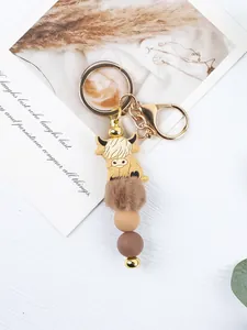 Detailed view of the silicone highland cow charm with brown fur pompom and beads.