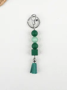 Detailed view of green silicone beads and tassel on a handmade keychain charm.