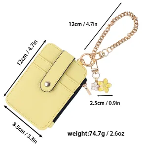 Detailansicht eines gelben Leder-Kartenhalters mit goldener Blumenanhänger-Kette.