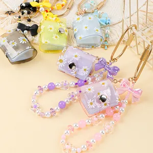 Close-up of colorful mini transparent daisy photo album keychains with beaded wristlets