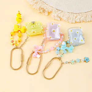 Close-up of mini daisy photo album keychains featuring colorful beaded wristlet straps