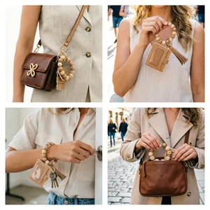 Lifestyle view of a wooden bead wristlet keychain with PU leather card holder and tassel.