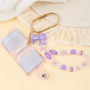 Detailed view of pink floral mini photo album keychain with purple beaded wrist strap charm
