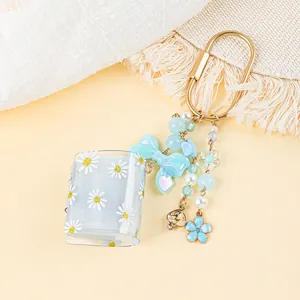 Detail of mini daisy photo album keychain with beaded blue bow and flower charms