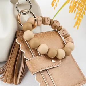 Close-up detail of a teacher-themed silicone bead keychain bracelet with card wallet.