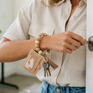 Close-up of a PU leather card holder and beaded bracelet keychain in a lifestyle setting.
