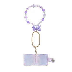 Purple beaded wristlet keychain featuring a mini transparent card holder photo album