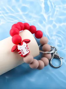 Close-up of a red and taupe silicone beaded keychain with a football jersey charm accessory