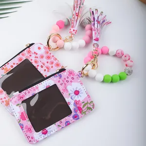 Detailansicht der bedruckten Leder-Kartentasche mit bunten Perlenarmband und Fransen