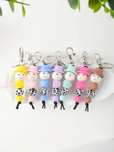 Detail view of colorful silicone bead keychains featuring cow print and cute hats