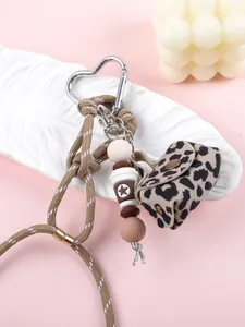 Close-up of leopard print mini pouch keychain with braided rope and beaded charms.