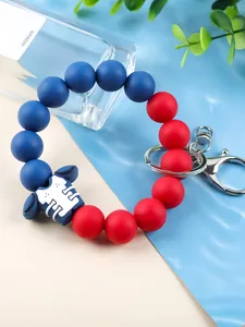 Detailed view of the red and blue silicone beaded keychain with a rugby jersey charm.