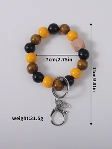 Detailed view of wooden beaded wristlet keychain with yellow and black beads, 14cm length