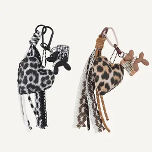 Detailansicht von Herz-Taschenanhängern mit Leopardenmuster, Ballonhund und Spitzenquasten