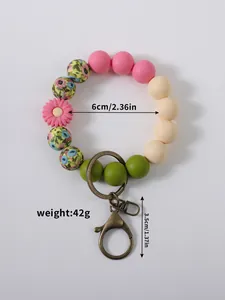Detail view showing 6cm diameter and 42g weight for this floral silicone bead keychain.