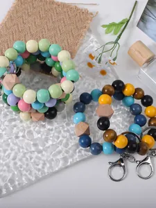 Detailed view of colorful wooden bead wristlet keychains with metallic lobster clasps