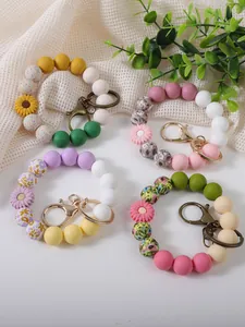 Detailed view of colorful daisy silicone wristlet keychains with floral DIY beads