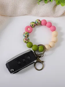 Detail of a floral silicone bead wristlet keychain with a daisy charm and car key