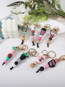 Detail view of coffee cup silicone bead keychains with wooden accents and metal lobster clasps.