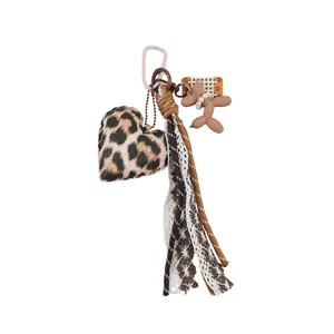 Stilvoller Taschenanhänger mit Leopardenherz und braunem Ballonhund sowie Spitzendetails