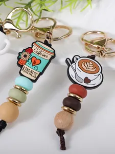 Detail view of coffee cup beaded keychain with silicone and wooden beads and gold clasp.