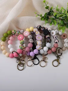 Close-up of colorful daisy silicone bead wristlet keychains with floral patterns