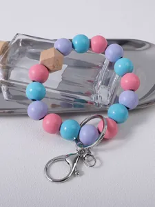 Close-up of a colorful beaded wristlet keychain with wooden accents and silver clasp