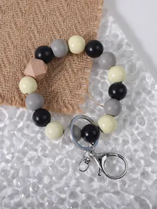 Close-up of wooden bead keychain with silver hardware on a burlap background