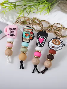 Close-up detail of coffee cup charms on keychains with mixed silicone and wooden beads.