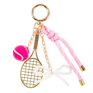Llavero de raqueta y pelota de tenis con cuerda rosa y lazo de perlas elegante