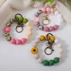 Colorful silicone beaded wristlet keychains with daisy charms on a white background.