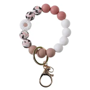 Pink and white silicone bead wristlet keychain with white daisy charm and gold metal lobster clasp