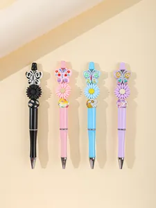 Close-up detail of colorful acrylic beaded ballpoint pens with butterfly and flower charms