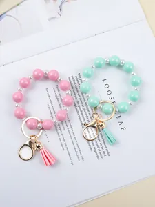 Detail view of pink and mint green silicone bead wristlet keychains with tassels.