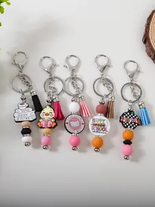 Five assorted silicone beaded keychains with colorful tassels and school-themed charms.