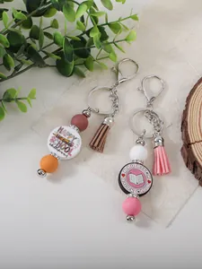 Detailed shot of silicone beaded keychains with colorful tassels and school slogans