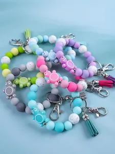 Detailed group view of colorful silicone beaded turtle keychains with tassels and clasps