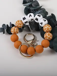 Détail rapproché du porte-clés en perles de silicone avec motif girafe et perles MAMA