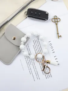 Detailed close-up of a white marble silicone bead bracelet keychain with white leather tassel