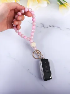 Vista dettagliata del portachiavi a bracciale con perline di silicone rosa tenuto in mano