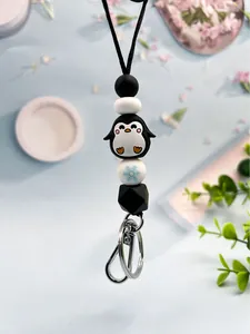 Detail shot of a silicone beaded lanyard with a cute penguin charm and snowflake bead