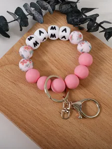 Vue détaillée d'un porte-clés en perles de silicone rose avec motif floral et MAMA
