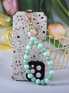 Primo piano del cinturino in silicone verde menta su una cover con motivo terrazzo.