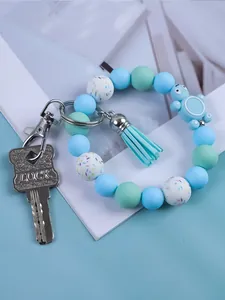 Detail shot of a cute blue silicone beaded keychain with a turtle charm and tassel