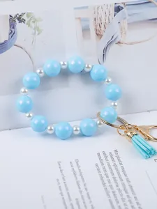 Detail view of light blue silicone beads and white pearl beads with tassel keychain.